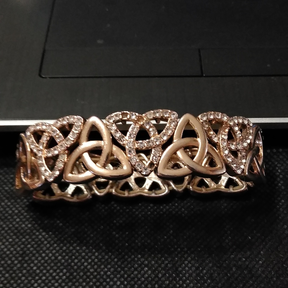 Celtic knot gold plated bracelet with simulated dias. Elastic, 2.5 inches wide
